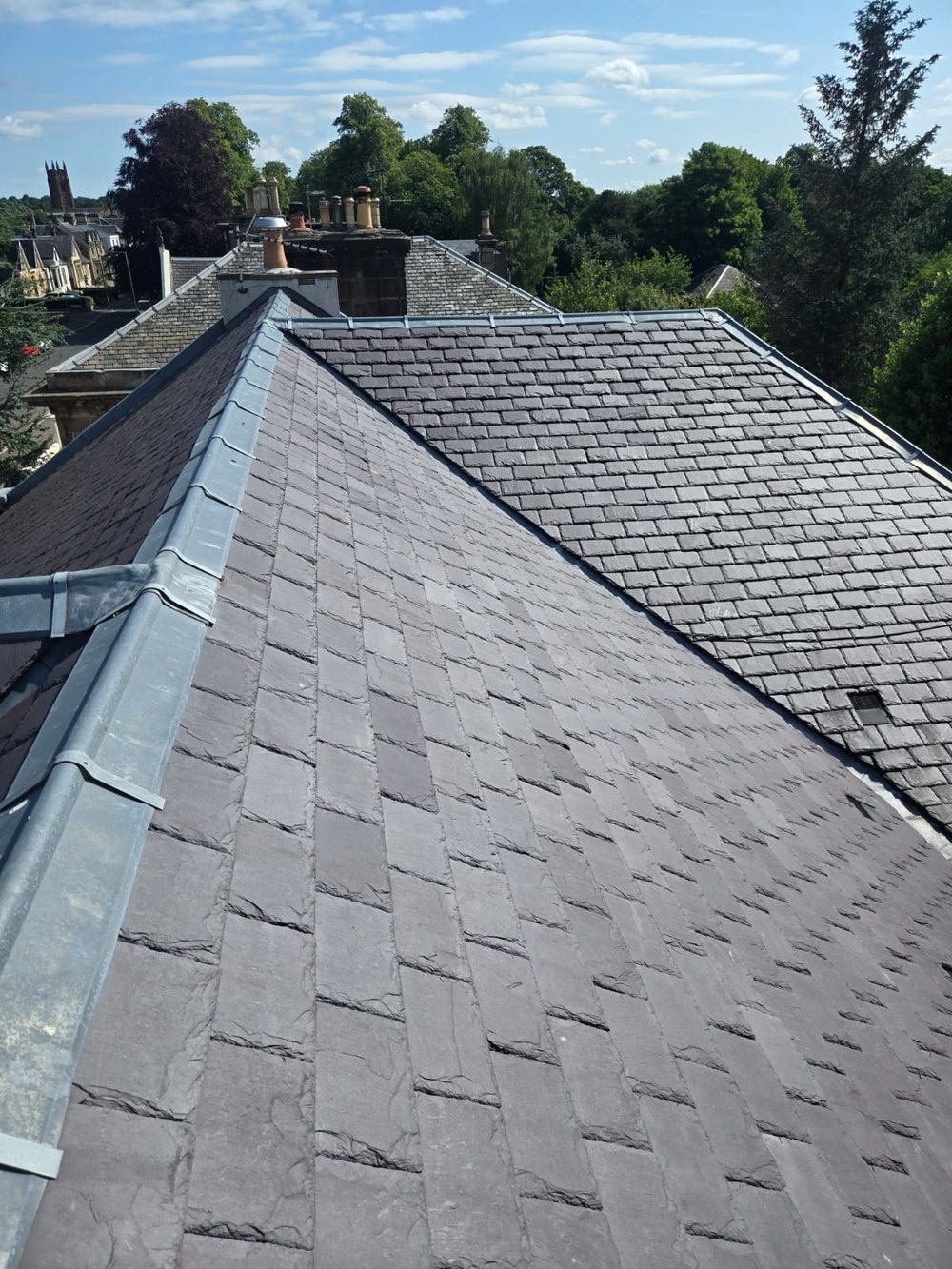 New slate roof around a rebuilt sandstone chimney